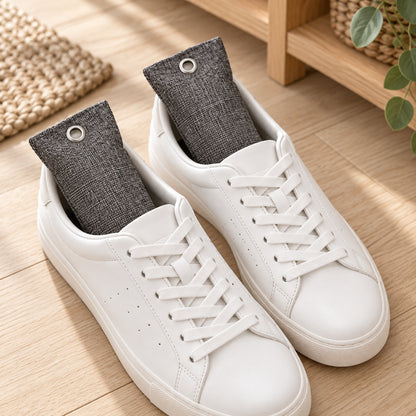 Två aktivt kol-påsar à 100 g av bambukol i ett par vita sneakers – tar bort lukt och fukt i skor